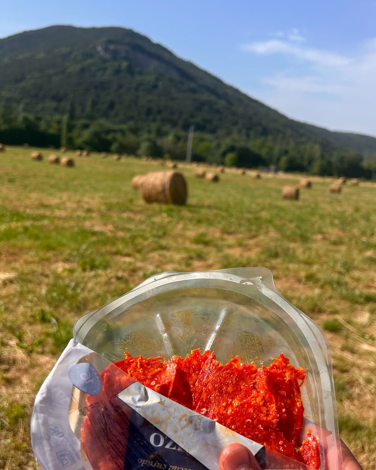 A roadside lunch held up against fresh hay bales and green hills in Navarra.