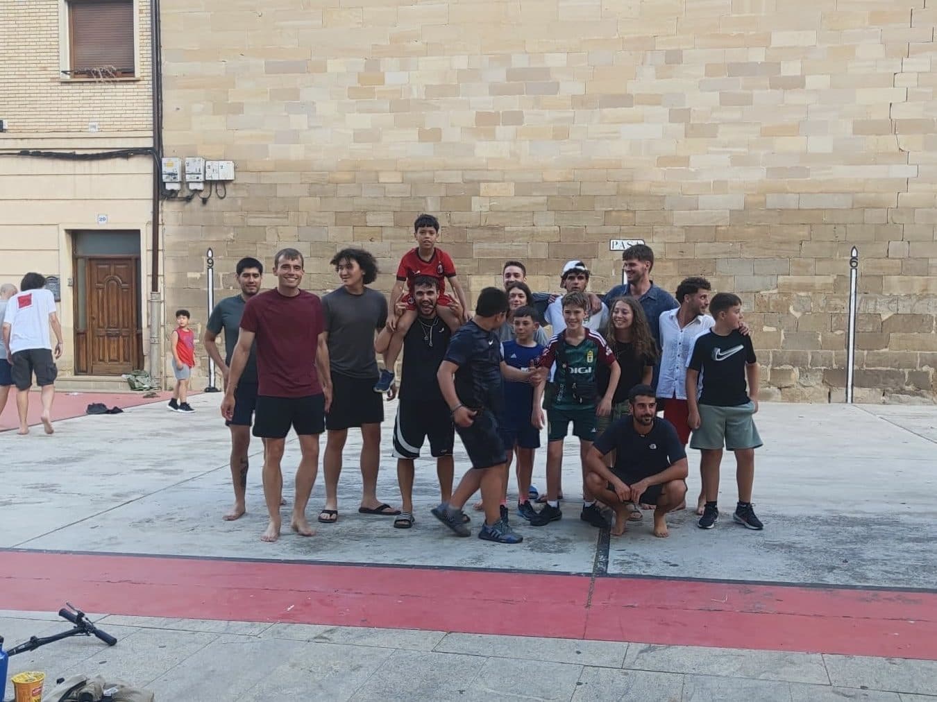 A crowd of pilgrims gathered for an evening game on a village fronton court.