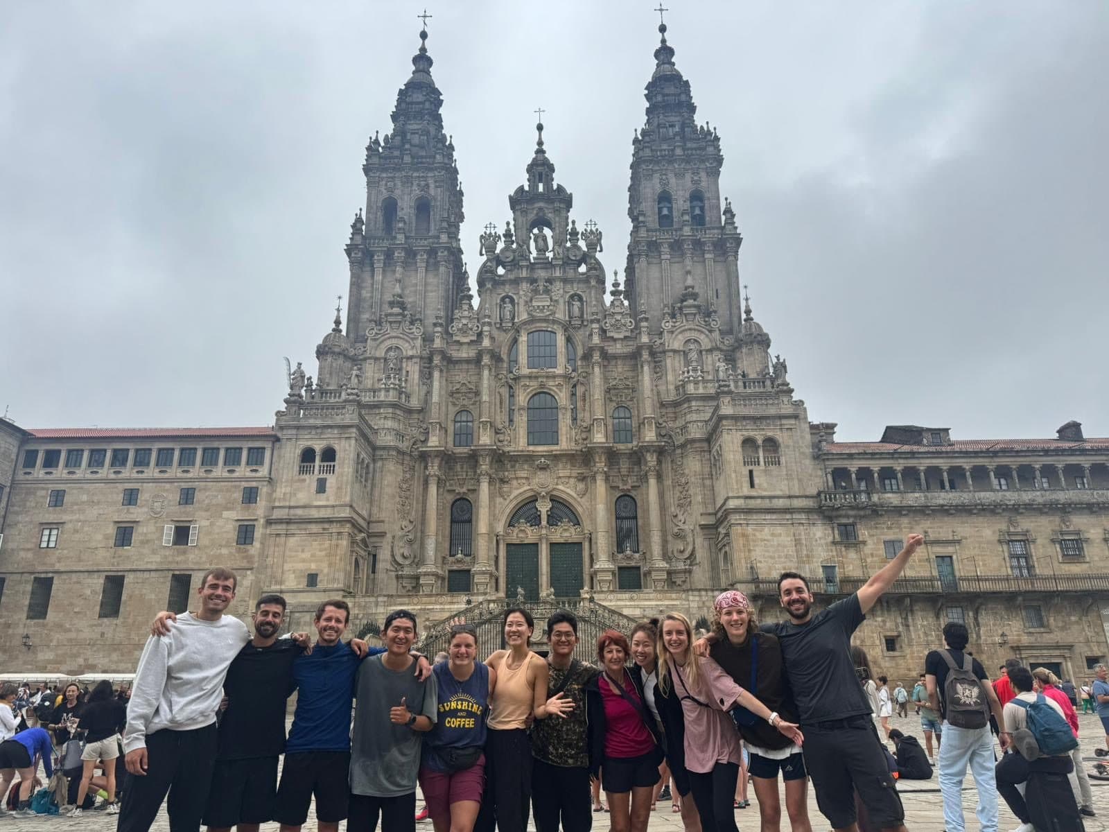 The whole walking family celebrating together in Praza do Obradoiro before the cathedral.
