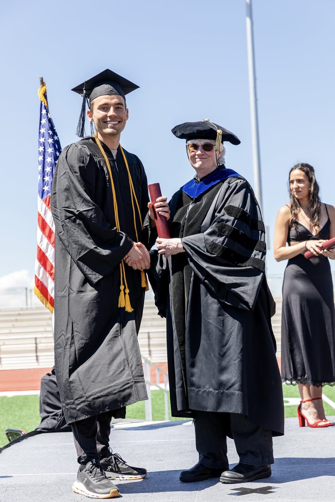 Kyle Wisniewski crossing the stage at Western Colorado University's commencement, graduating cum laude.