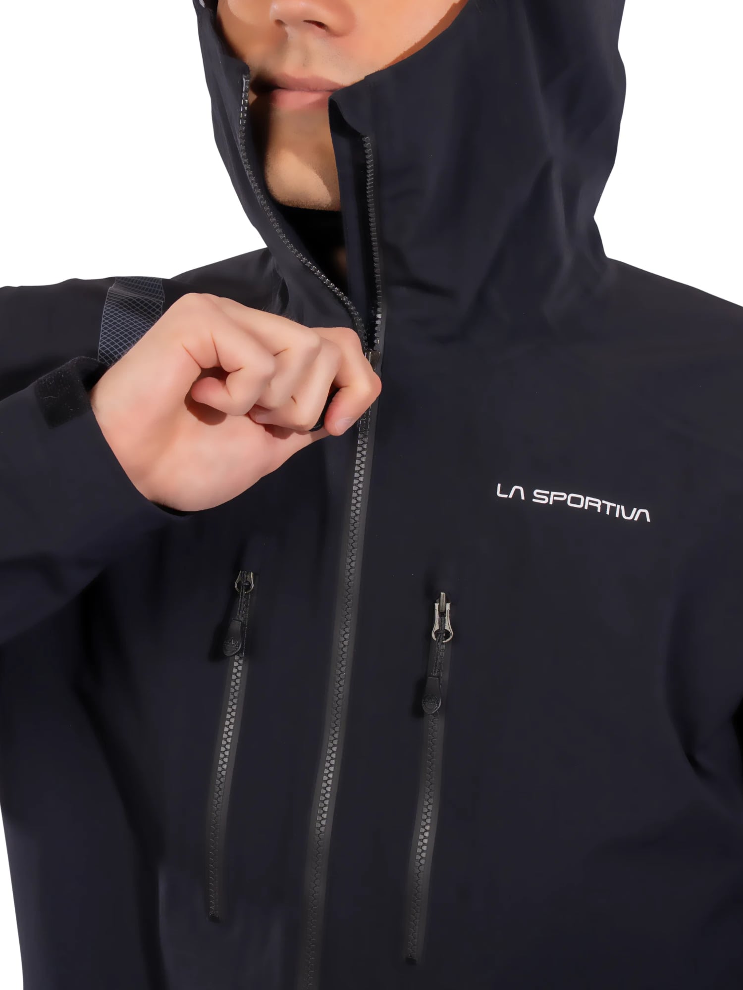 Kyle Wisniewski, hood up, pulling the zip of a black La Sportiva jacket to his chin, the chest logo and pocket zips in view