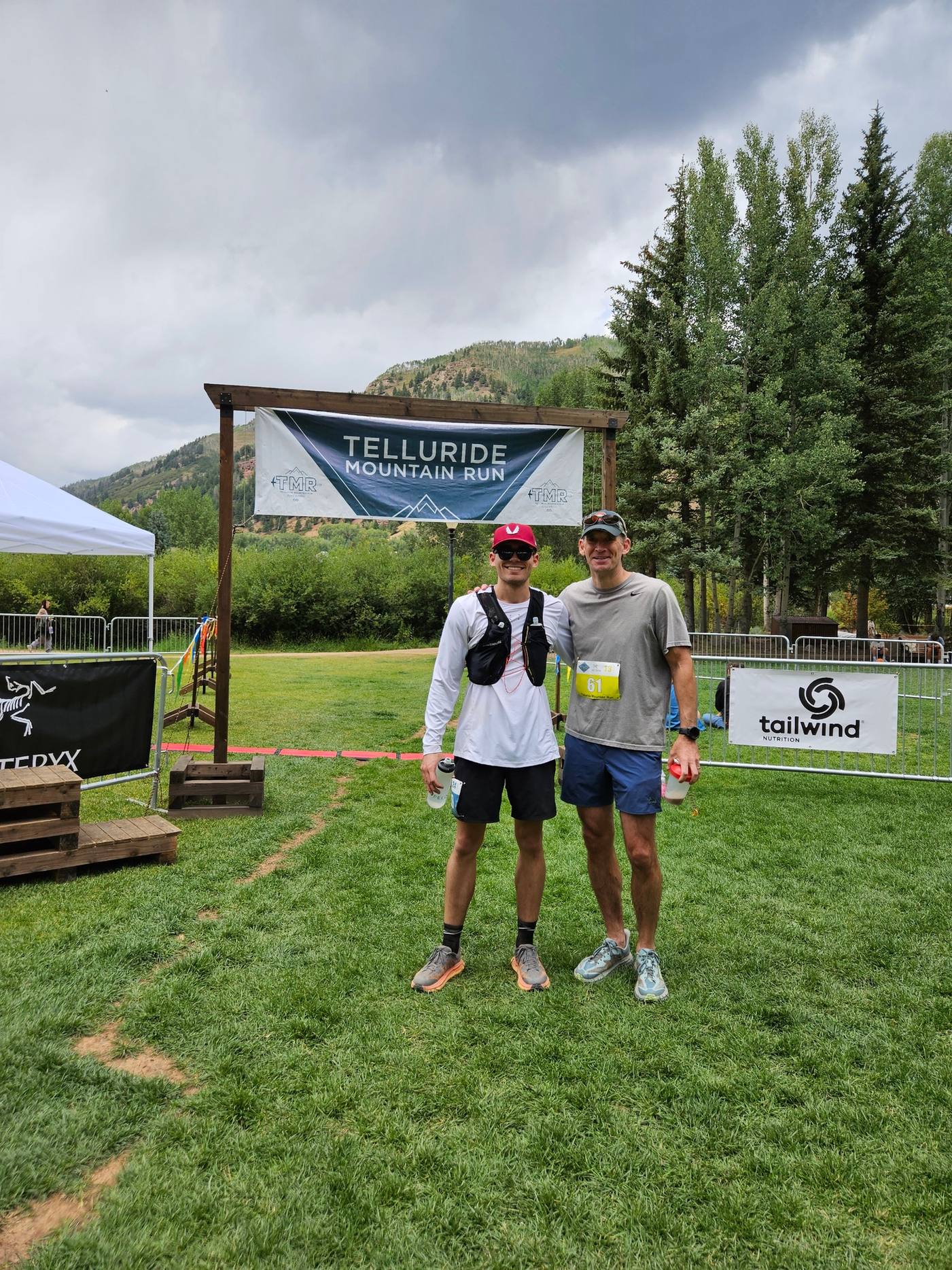 Kyle Wisniewski and another runner standing under the Telluride Mountain Run banner after the race.